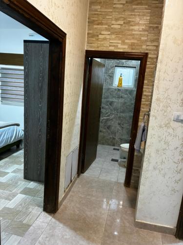 a bathroom with a toilet and a glass door at New Roman's kingdom in Madaba