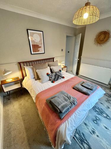 a bedroom with a bed with two towels on it at Sea Song Cottage in Broadstairs