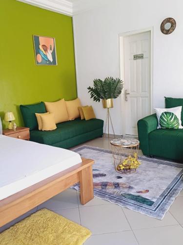 ein Wohnzimmer mit grünen Möbeln und einem Sofa in der Unterkunft Résidence Meublée Pachira I in Abidjan