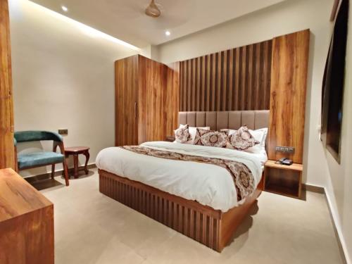 a bedroom with a large bed and a blue chair at Hotel Absolut Comfort 500 MTR FROM GOLDEN TEMPLE in Amritsar