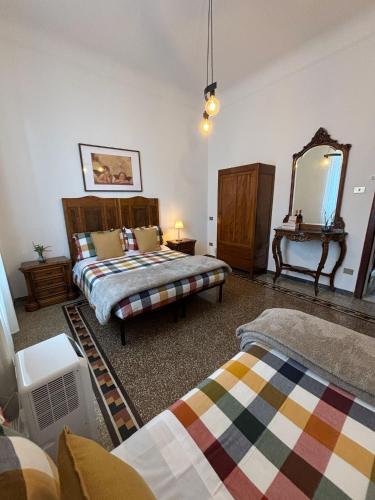 a bedroom with two beds and a mirror at La Casa di Eli Appartamenti in Pisa