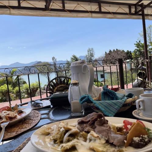 a table with plates of food on a balcony at Villas Paraiso Valle de Bravo in Valle de Bravo