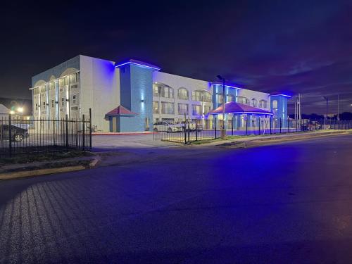 a building with blue lights in front of it at night at Hallmark Inn & Suites Newly Renovated Rooms San Antonio Northeast in San Antonio