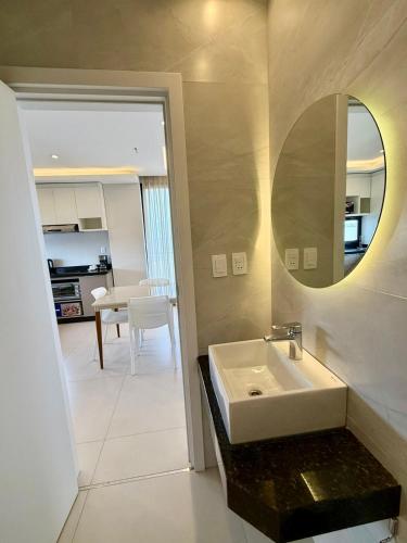 un bagno bianco con lavandino e specchio di Milord Suites a Encarnación