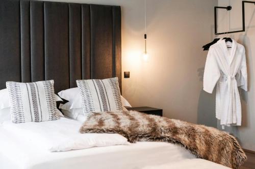 a white bed with a fur blanket on top of it at Hotel Vestmannaeyjar in Vestmannaeyjar