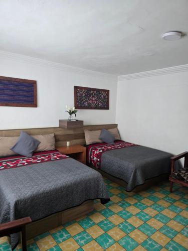 a bedroom with two beds and a table at Casa en Centro histórico Alojamiento completo in Veracruz