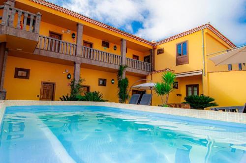 a swimming pool in front of a house at Hotel El Tejar & Spa in Vilaflor