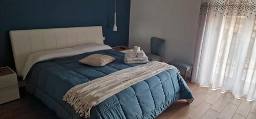 a bedroom with a bed with a blue comforter at Casa GIOIA Luxury in Taranto