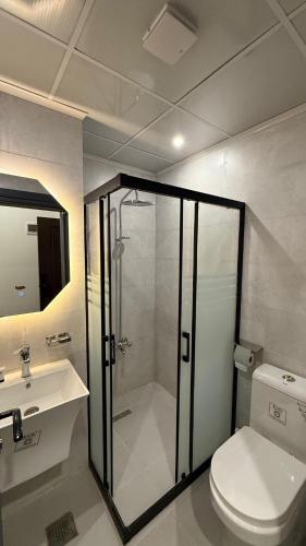 a bathroom with a shower and a toilet and a sink at Abraj Al Madina Hotel in Al Fayşalīyah