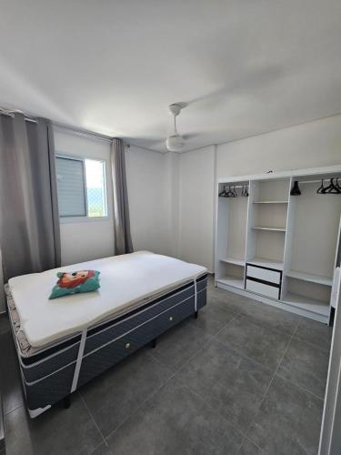 a bedroom with a bed in a room with shelves at Apto 83 in Itanhaém