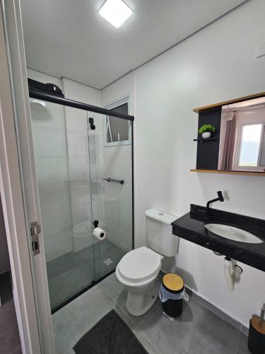 a bathroom with a toilet and a shower and a sink at Apto 83 in Itanhaém