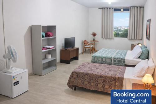 a hotel room with two beds and a television at Hotel Central in Amparo