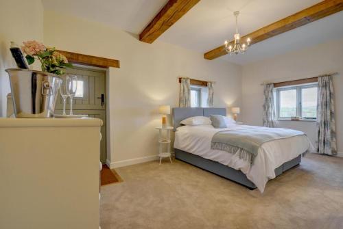 a bedroom with a large bed and two windows at 2 Bed in Bishops Nympton oc-barton in Bishops Nympton