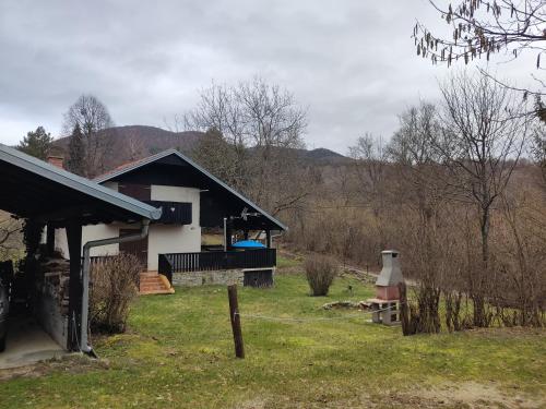 a house in a field with a fence and a yard at Uskočki san in Sošice