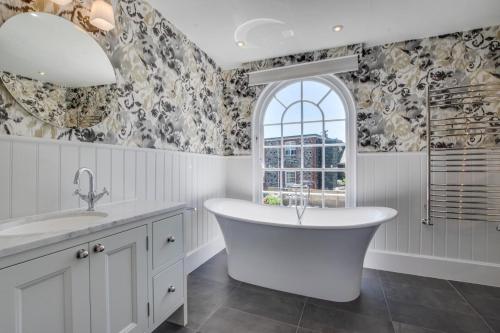 a bathroom with a white tub and a window at 6 Bed in Padstow oc-p00760 in Padstow
