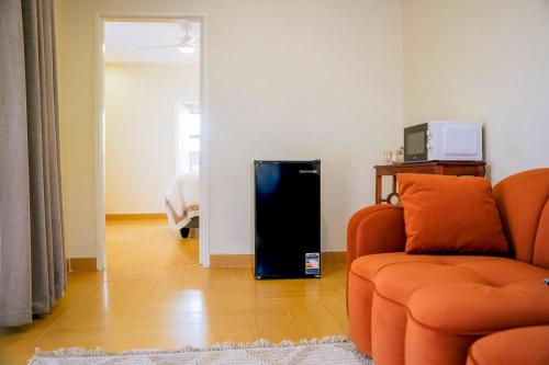 a living room with a couch and a refrigerator at Sunderdale in Gweru