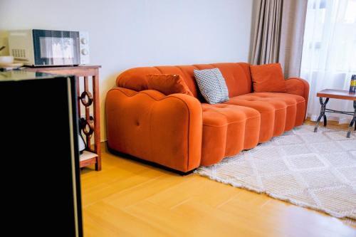 an orange couch sitting in a living room at Sunderdale in Gweru