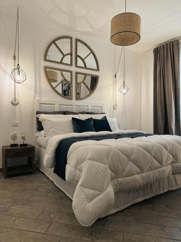 a white bedroom with a large bed and a mirror at Libeccio - Villa Marina in Marina di Andora