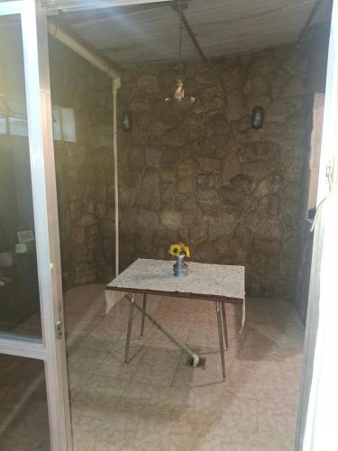 a table in a room with a stone wall at Aconchego in Juiz de Fora