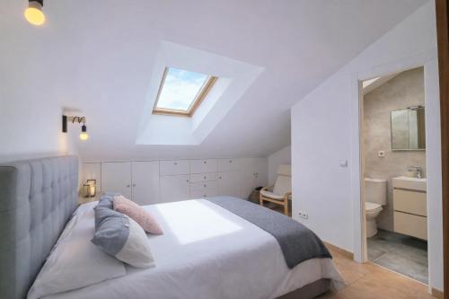 a bedroom with a bed and a bathroom with a window at El Rincon de las Americas in Colombres