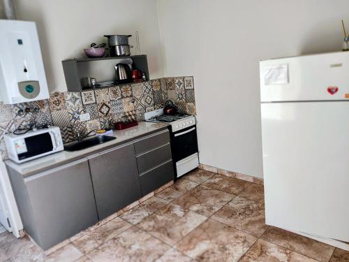 a small kitchen with a stove and a refrigerator at Depto Civora 3 in Villa Regina