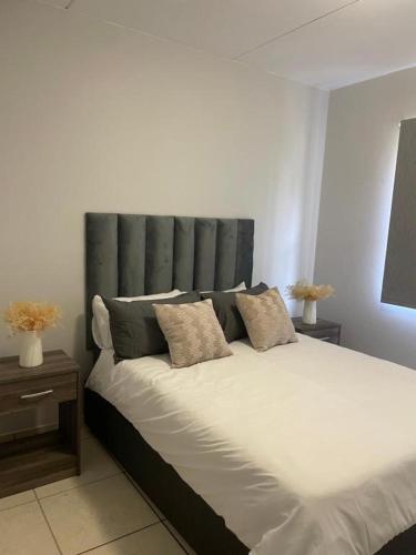a bedroom with a large bed with a gray headboard at Ballito Seasons in Ballito
