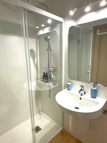 a white bathroom with a sink and a shower at Isla de los Pensamientos in Faro de Cullera