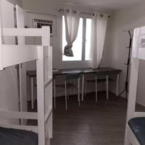 a bedroom with a desk and a bed with a window at Orwell Heights-Vista Recto in Manila