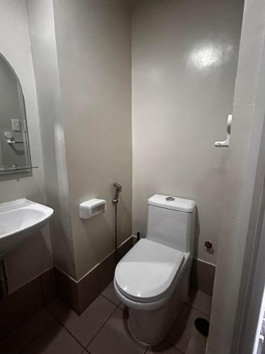 a bathroom with a white toilet and a sink at Orwell Heights-Vista Recto in Manila