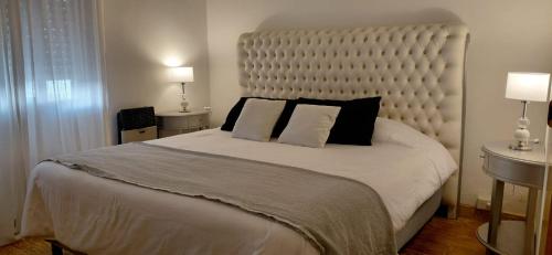 a bedroom with a large white bed with black pillows at Casa a Estrenar - Monte Hermoso in Monte Hermoso