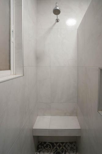 a white shower with a bench in a bathroom at Hotel New York Ciudad de Mexico in Mexico City
