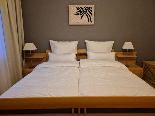 a bedroom with a large bed with white sheets and pillows at Komfortable 3-Zimmer- Wohnung in Ratingen