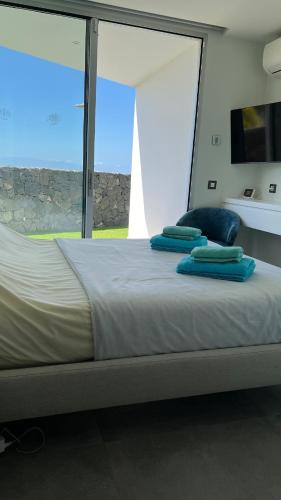 a large bed with blue pillows on top of it at Luxurious villa with ocean views in Callao Salvaje