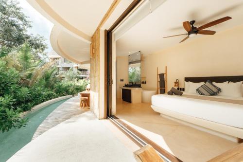 a bedroom with a bed and a large window at Kan Tulum Hotel in Tulum