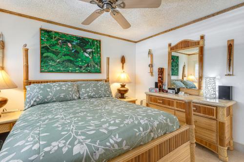 a bedroom with a bed and a dresser and a mirror at Condo with Private Lanai, Ocean View and On-Site Pool! in Kihei