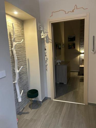 a hallway with a door with a chair and a bathroom at CAMARDA SUITE in Bernalda