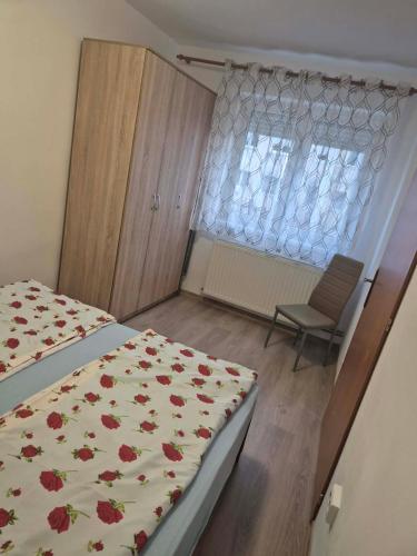 a bedroom with a bed and a window and a chair at Alexandra Home in Mediaş