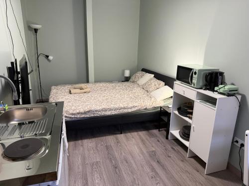 a small bedroom with a bed and a microwave at La Casa de Nido - Mini Studio in Veszprémfajsz