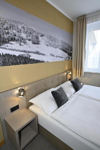 a bedroom with two beds and a painting on the wall at Vila Victory polopenze v Krušných horách in Abertamy