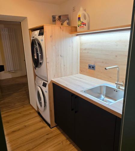 eine kleine Küche mit Spüle und Waschmaschine in der Unterkunft Sonneckalm in Berchtesgaden in Berchtesgaden