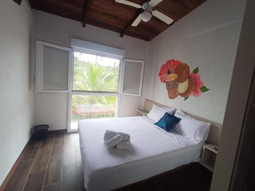 a bedroom with a white bed with a flower on the wall at Basi Resort in Nombre de Dios