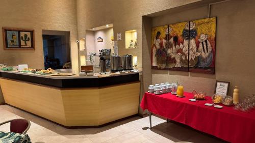 a restaurant with a counter and a table with a red cloth at Wilson Hotel in Salta
