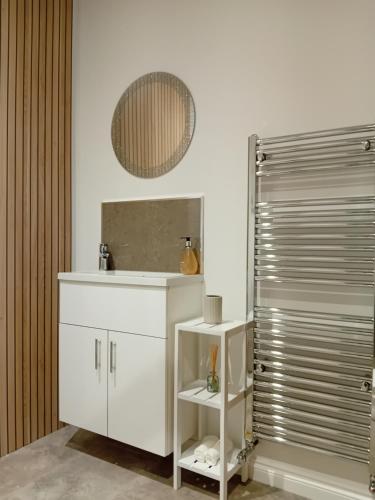 a bathroom with a white cabinet and a shower at The Snug on The Brae in Inverness