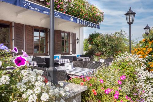 a street sign in front of a house with flowers at Hotel Neuer am See in Prien am Chiemsee