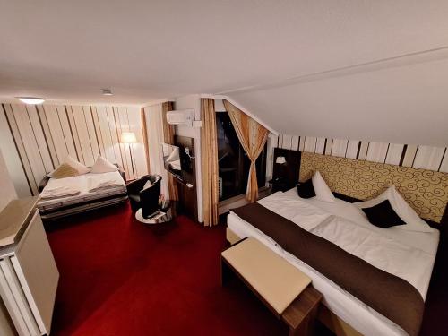 a bedroom with a large bed and a red carpet at Lobinger Parkhotel & Restaurant in Giengen an der Brenz
