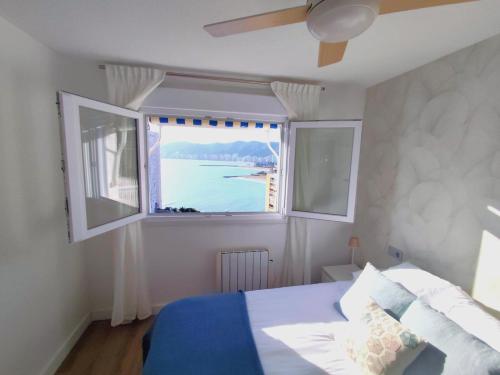a bedroom with a bed and a large window at Isla de los Pensamientos in Faro de Cullera