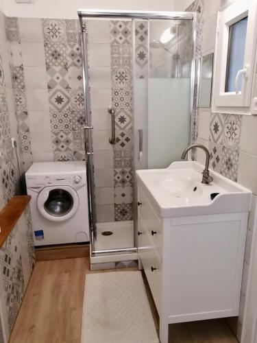 a bathroom with a washing machine and a sink at Gîte Bouconne Pibrac in Pibrac