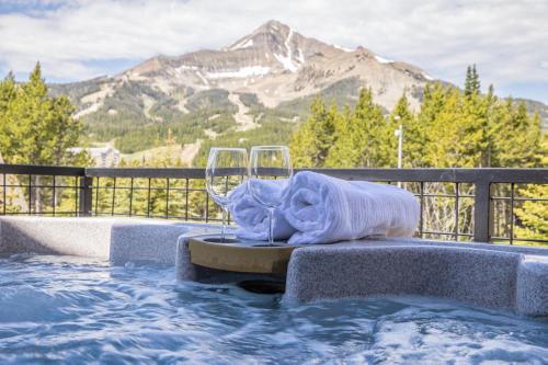 a hot tub with a bed and two wine glasses at Alpenglow Condo 36A in Big Sky