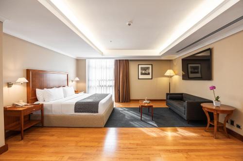 ein Hotelzimmer mit einem Bett und einer Couch in der Unterkunft Oro Verde Guayaquil in Guayaquil