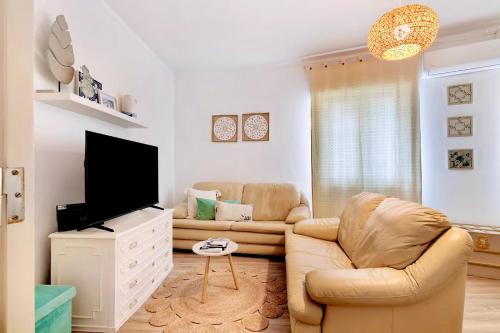 a living room with a couch and a flat screen tv at Caíque - Apartamento de Charme com 3 Quartos no Centro Histórico de Olhão in Olhão